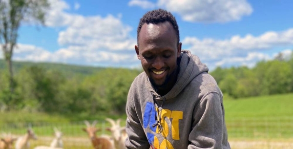 A former refugee and now farmer member of the Somali Bantu Community Association in Lewiston, Maine, tends to a goatherd. — courtesy Hazel Plunkett