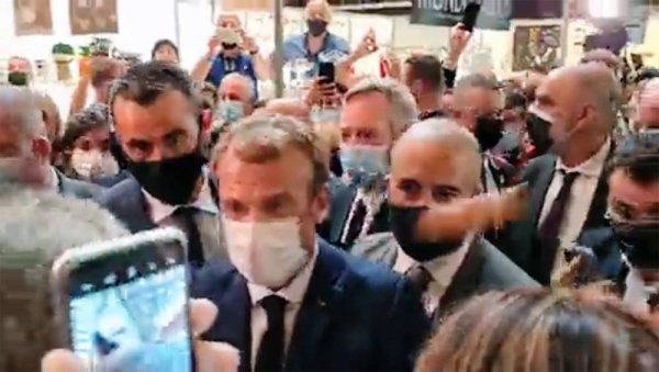 A videograb shows French President Emmanuel Macron unaware of the 'egg' missile being thrown at him during his visit to a restaurant trade fair in Lyon. The egg bounced off Macron's shoulder without breaking. 