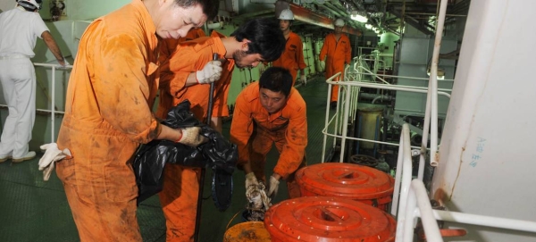 Seafarers work in the engine room of a Chinese registered ship in the Port of Genoa in Italy.