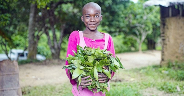 A child holds vegetables grown in her garden in a village in Cameroon. — courtesy CIFOR/Ollivier Girard