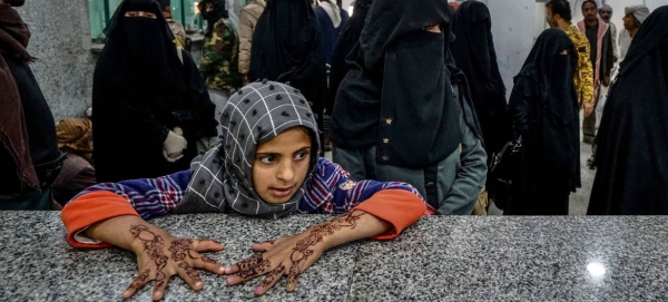 Recently displaced people wait to receive emergency aid in Marib, Yemen.