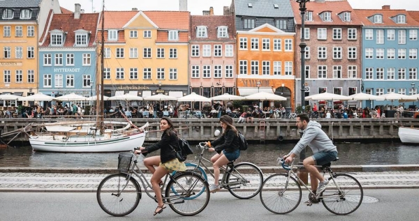 Tourists biking at Nyhavn in Copenhagen, Denmark. — courtesy Unsplash/Febiyan