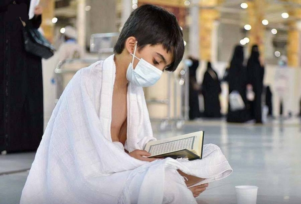 A Muslim boy performs Al-Fajr prayer Sunday at the Grand Mosque amid atmosphere full of faith.