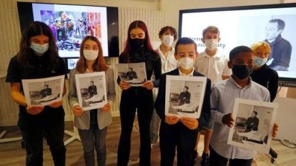 Children showing photos of Samuel Paty, who was beheaded last year outside his Paris school by an 18-year-old Chechen refugee, mark the first anniversary of the teacher's death.