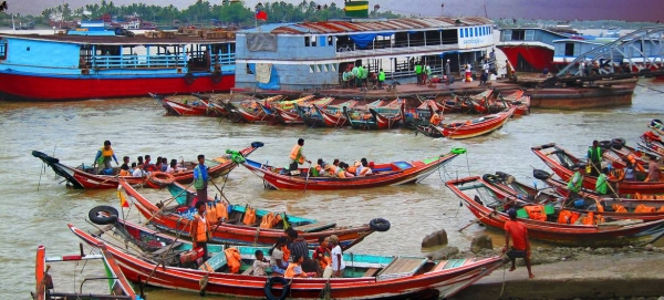 Boats leave the shoreline of Myanmar