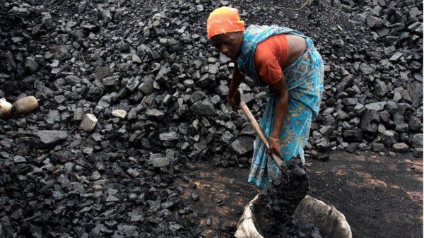 A woman shovels coal in a brick kiln at Kamduni in India's West Bengal state.