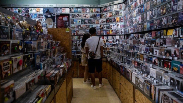 Customers looking at movies for sale at a store inside a cinema in Hong Kong.