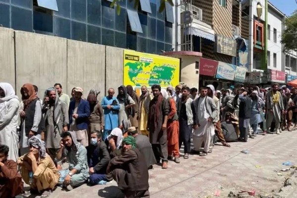 Afghans in capital Kabul line up outside a bank to take out cash.