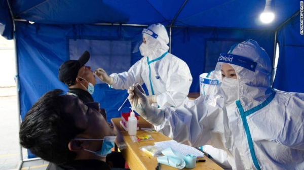 Medical staff take a swab sample from a man to be tested for the Covid-19 coronavirus in Ganzhou District in Zhangye, in China's northwest Gansu province on October 29.
