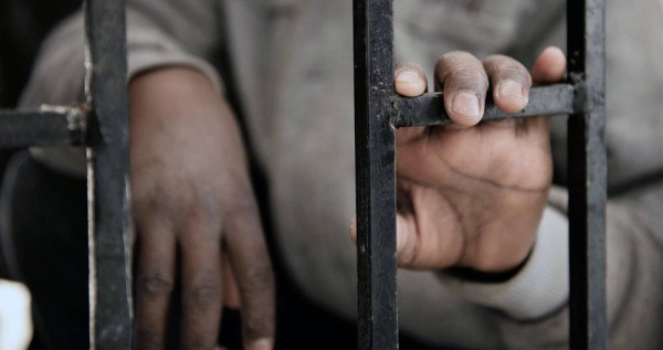 A fourteen-year-old migrant from Niger rests his hand on a gate inside a detention centre, in Libya. — courtesy UNICEF/Alessio Romenzi