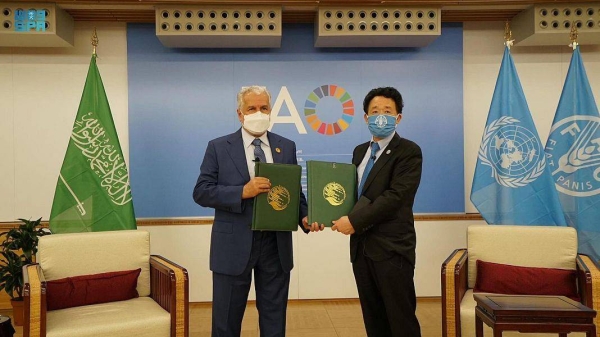 Dr. Abdullah Al-Rabeeah and Director General Qu Dongyu exchange documents after signing two agreements in Rome on Wednesday.