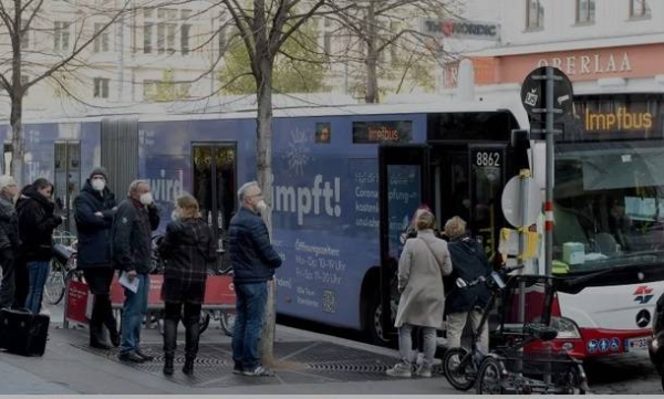 Austrians wait in front of a vaccination bus during the COVID-19 outbreak.