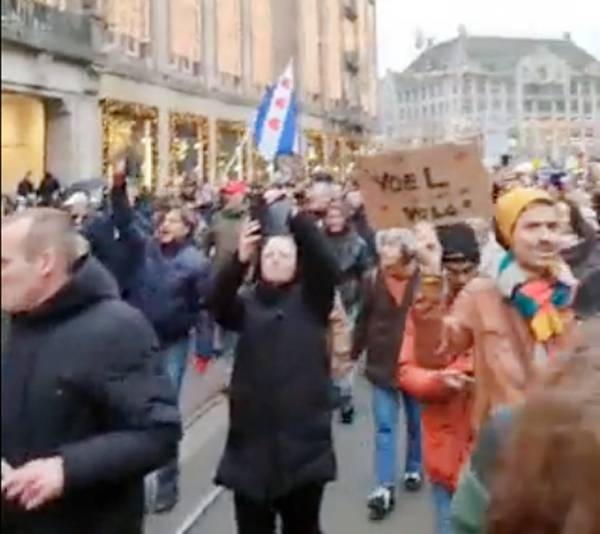 Protesters march in downtown Rotterdam against COVID-19 restrictions.