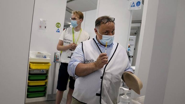Belgium's chief virologist Mark Van Ranst prepares to administer the COVID-19 vaccine in Antwerp, Belgium.