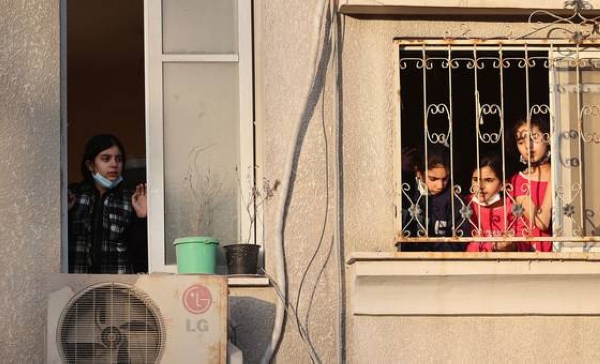 Palestinian children look out from their window at destroyed buildings in their neighborhood in the Gaza City.
