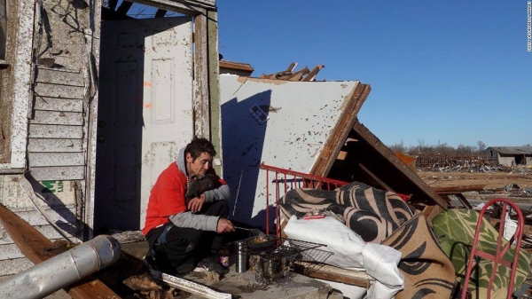 Bogdan Gaicki sits among debris on Sunday, December 12, in the Kentucky town of Mayfield after extreme weather hit the region.