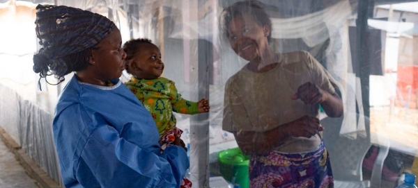 A five-month-old baby smiles when he sees his mother through the plastic that separates them at an Ebola Treatment Center (ETC) in Beni, North Kivu province, Democratic Republic of the Congo.