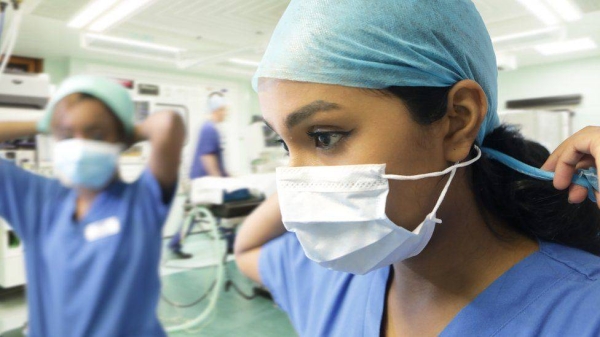 Medical professionals putting on PPE.