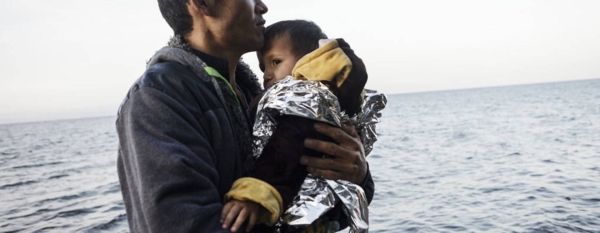 A young refugee from Afghanistan holds his young son and looks at the sea after reaching safely the shores of Lesbos island, having crossed the Aegean sea from Turkey in an inflatable boat full of Afghan refugees. (file)