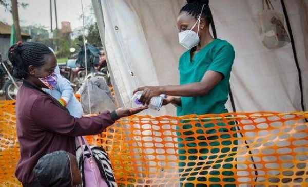 A nurse dispenses hand sanitizer to a visitor at a hospital in Masaka, Uganda.
