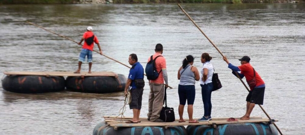 A group of people cross the Suchiate River on a raft, crossing the border between Guatemala and Mexico, in November 2021. — courtesy UNIC Mexico/ Luis Arroyo