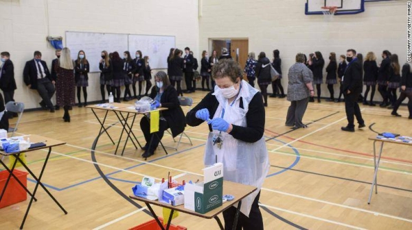 Staff at Park Lane Academy process students' Covid-19 lateral flow tests on the first day of term, in Halifax, northwest England on January 4.