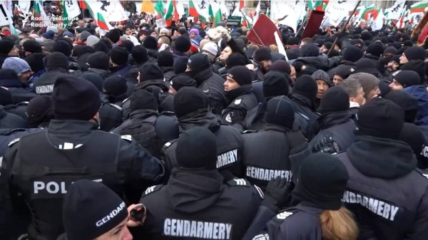 Crowds of protesters push against police cordons as they try to enter Bulgaria's parliament building in Sofia on January 12, 2022.