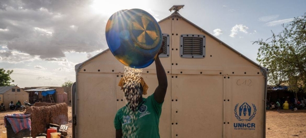 An internally displaced woman prepares food for her family in Burkina Faso.