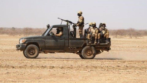 Burkina Faso soldiers patrol aboard a pick-up truck on the road from Dori to the Goudebo refugee camp.