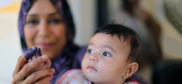 A mother holds up hers and her daughter's inked fingers at a polling station in the eastern city of Benghazi after casting her vote in historic elections.