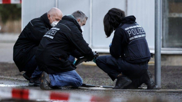 Police officers examine a weapon near the crime scene at Heidelberg University.