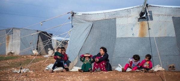 Children sit outside their family tent at the Alzhouriyeh makeshift camp in east rural Homs, Syria.