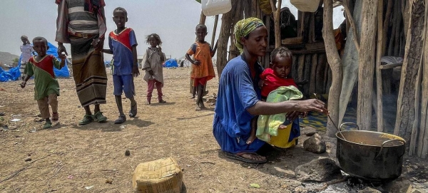 A displaced mother cooks for her family in Afar, Ethiopia.