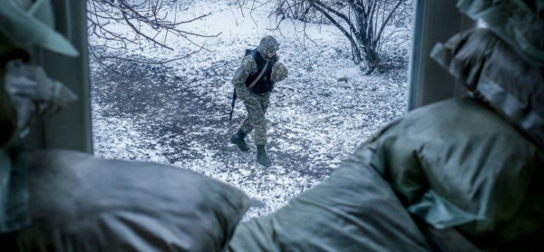 An armed police officer patrols outside a classroom in Donetsk Oblast, Ukraine.