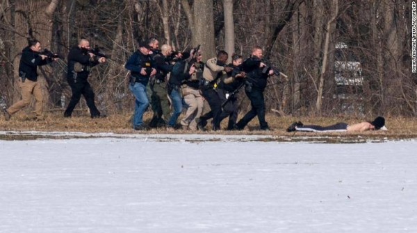 Police approach the suspect on the south bank of the North River.