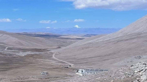 The border area in Humla, Nepal, with Chinese buildings in the foreground and snow-covered Mount Kailash far away.