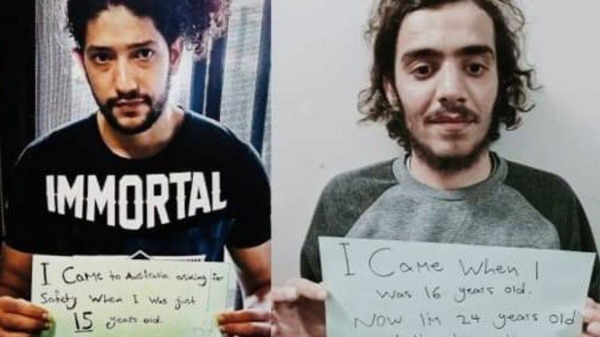 Refugees Mehdi Ali (left) and Mohammad (right) hold up signs saying they arrived in Australia as teenagers and have been detained for a decade.