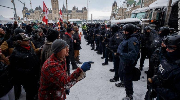 Protesters and police face each other as police move in to clear Ottawa of protesters on Saturday.