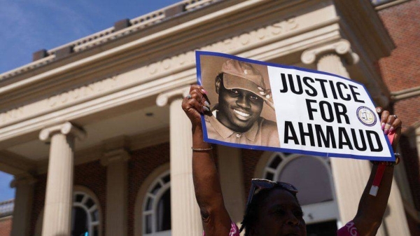 A demonstrator holds a sign in support of Ahmaud Arbery outside the Glynn County Courthouse.
