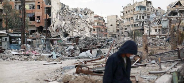 A man walks in front of destroyed buildings in Harasta, Syria. — courtesy UNICEF/Amer Almohibany