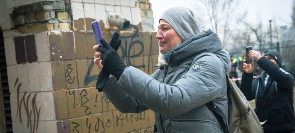 On February 25 in Kyiv, Ukraine, a resident photographs her apartment building, which was heavily damaged during ongoing military operations
