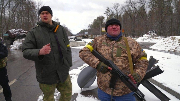 Johnny Dragan (left) and one of his soldiers at a Ukrainian checkpoint northwest of Kyiv.