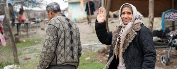 A Roma woman waves hello in Chirnogi, Romania.