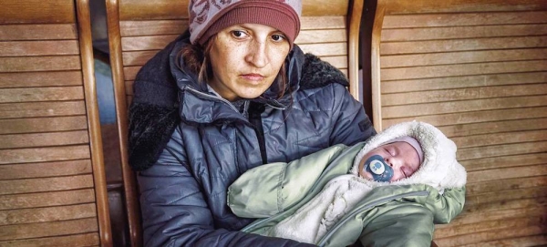 Lyuba with her two-month-old child sits in a train station in Uzhhorod after fleeing conflict in Ukraine. — courtesy UNICEF/Olena Hrom
