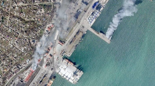 In this satellite photo from Planet Labs PBC, a Ukrainian naval vessel and a nearby building burn in the besieged city of Mariupol, Ukraine, Wednesday, April 6, 2022.