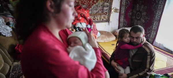 Parents comfort children after shelling by separatist forces in Novognativka, eastern Ukraine. in February 2022.