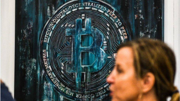 A woman walks past a Bitcoin-themed art installation during the Bitcoin 2022 Conference at the Miami Beach Convention Center in Miami Beach, Florida, on April 7, 2022.