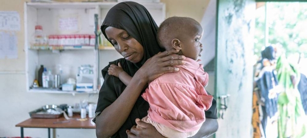 A mother in Wajir, Kenya brings her child to a health center to be weighed. — courtesy WFP