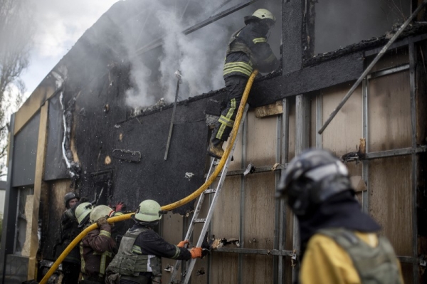 Firefighters work to extinguish a fire in a commercial area following a rocket attack in the Saltivka area of Kharkiv, Ukraine, on April 26.