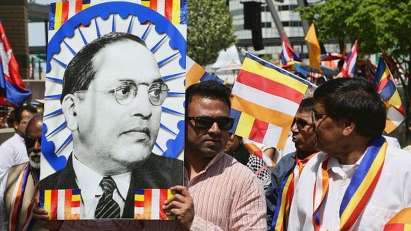 A man holds a large poster of Dr. BR Ambedkar during a rally in Canada. Dalit activists and academics are trying to bring caste discrimination to light in the West.